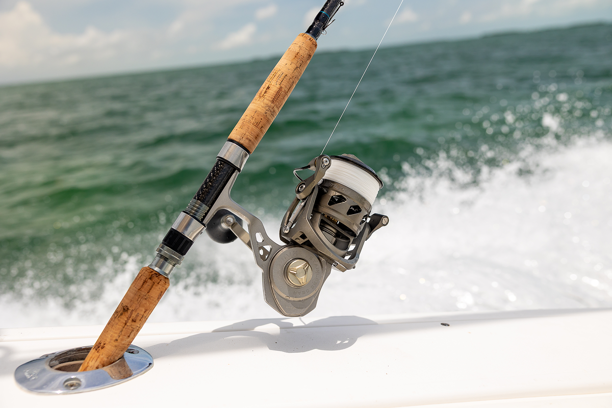 Fishing rod and reel on a boat with ocean waves in the background