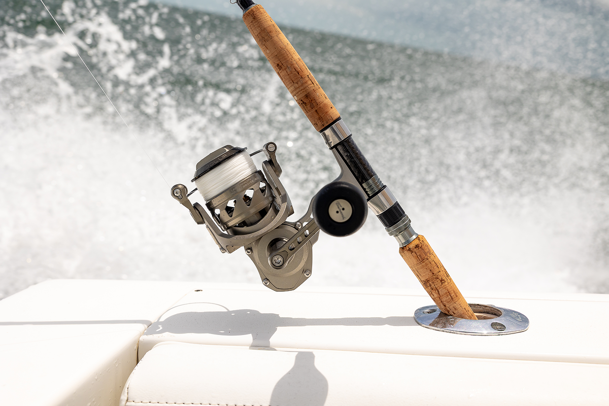 Fishing rod and reel on a boat with water splashing in the background