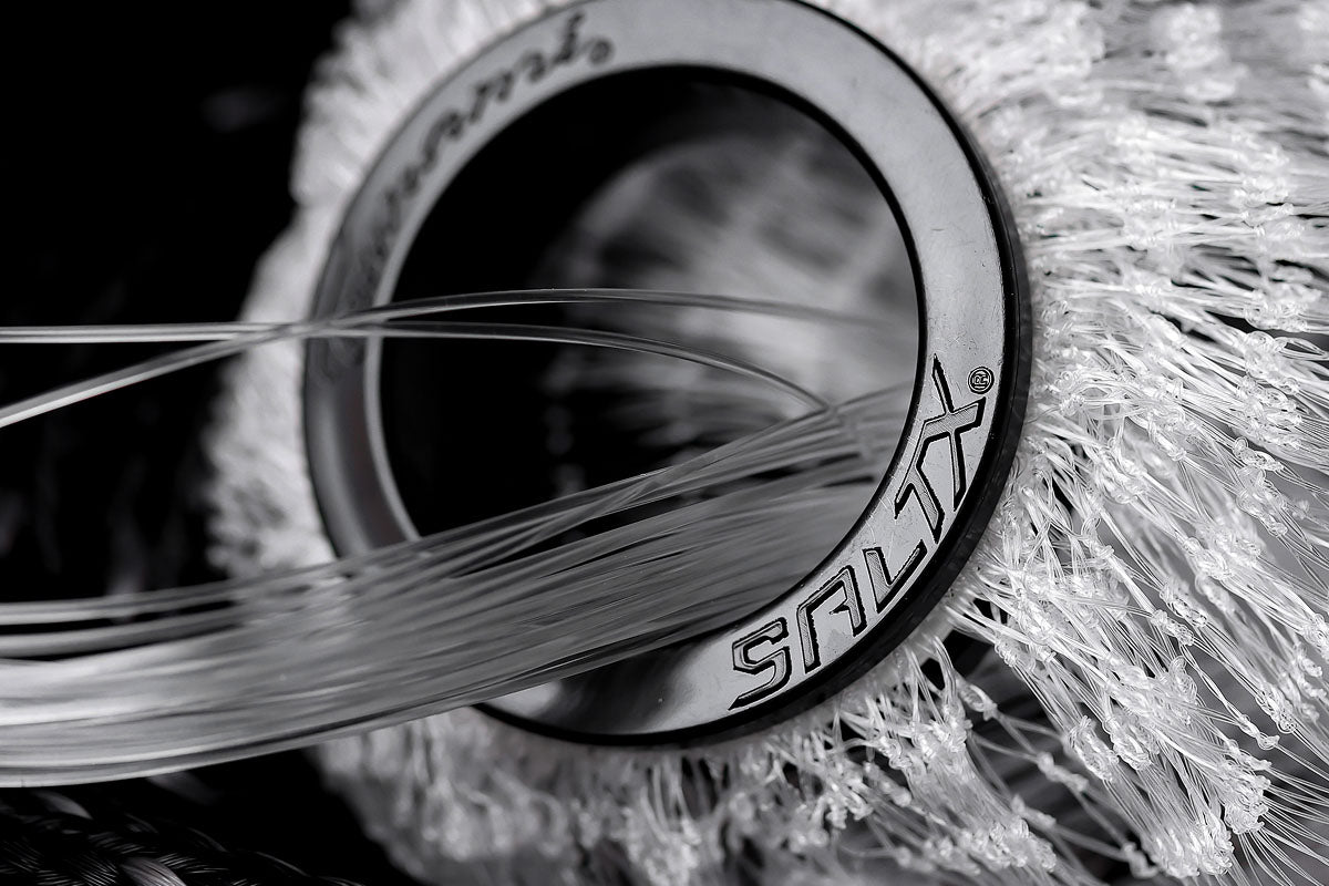 Close-up of a brush with 'SALTX' branding on a dark background