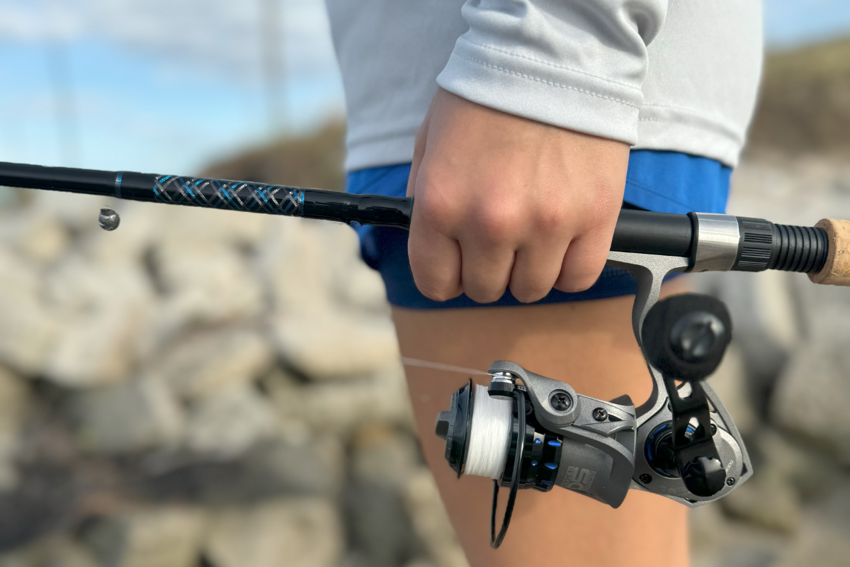 Person holding a fishing rod with a blurred natural background