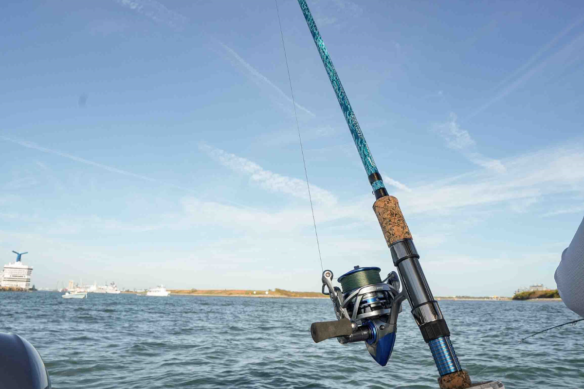 Fishing rod with reel over water and sky